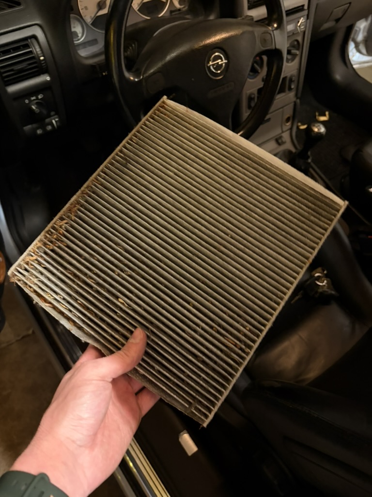 Ausgebauter, verschmutzter Innenraumfilter im Opel Astra G Cabrio